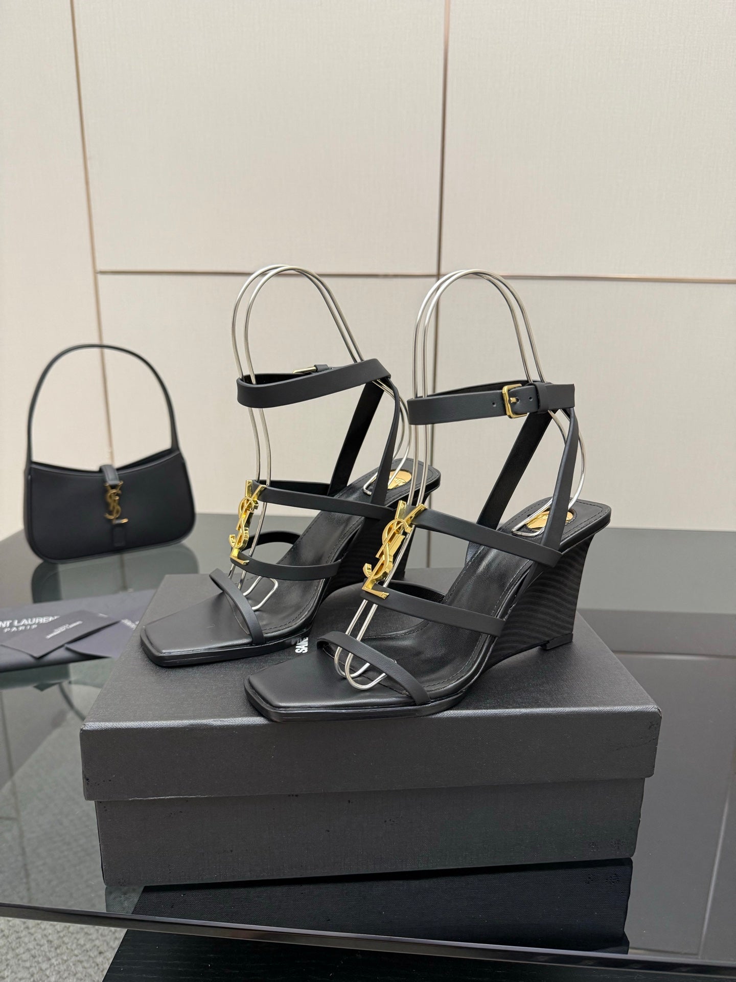 Black heeled sandals with gold chain detail and ankle-strap hardware
