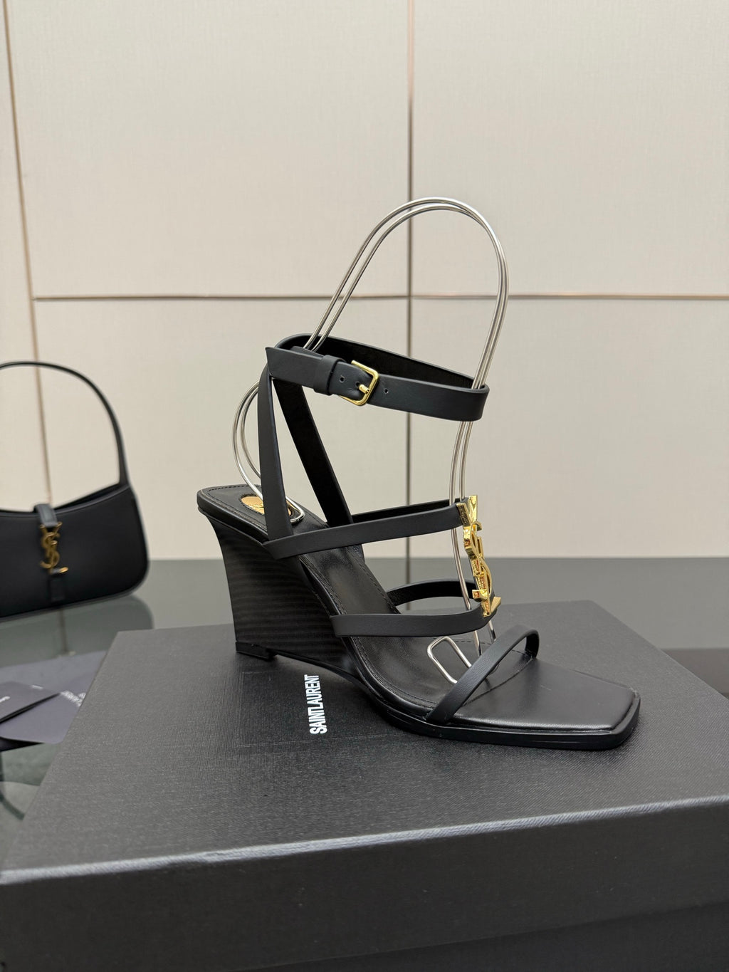 Black heeled sandal with gold chain detail and clear ankle strap close view