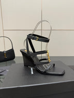 Black heeled sandal with gold chain detail and clear ankle strap close view