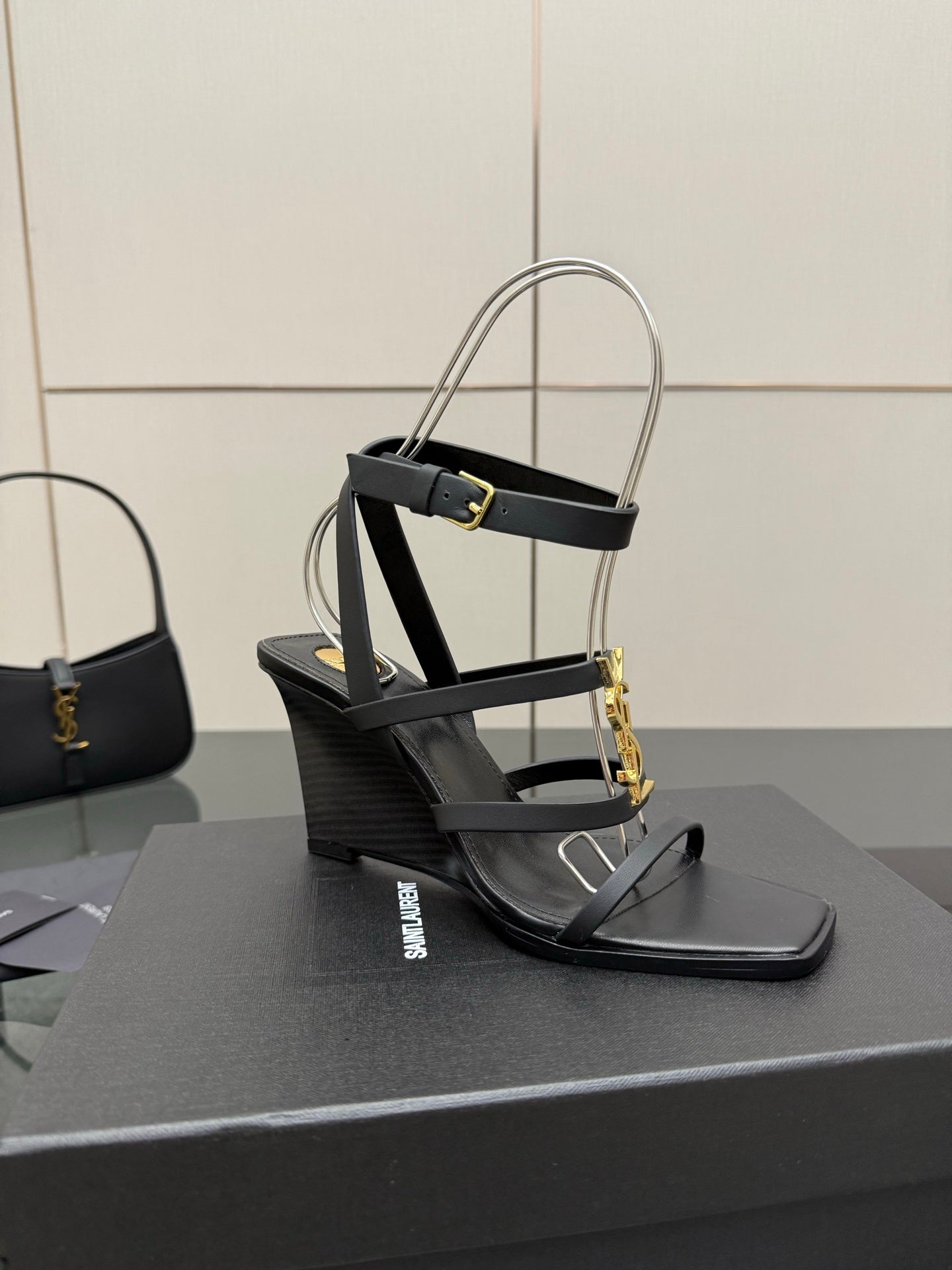 Black heeled sandal with gold chain detail and clear ankle strap close view