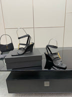 Black heeled sandal pair with gold chain detail and clear ankle straps