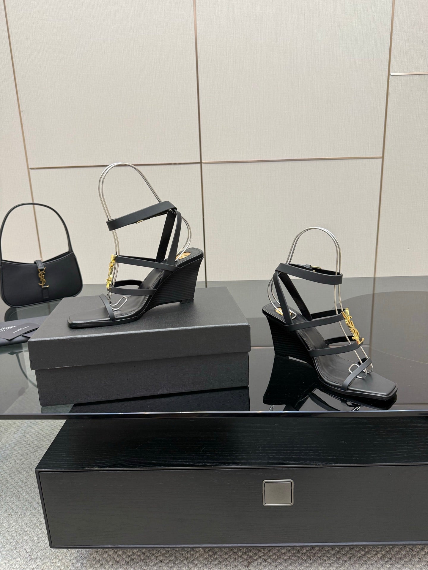 Black heeled sandal pair with gold chain detail and clear ankle straps