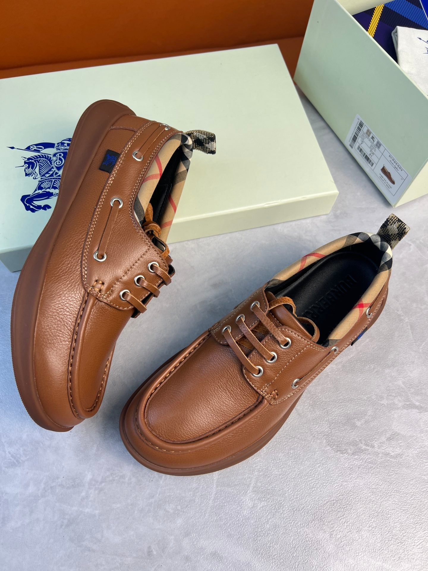Burberry brown leather lace-up boat shoes with checkered collar detail and rounded moc toe