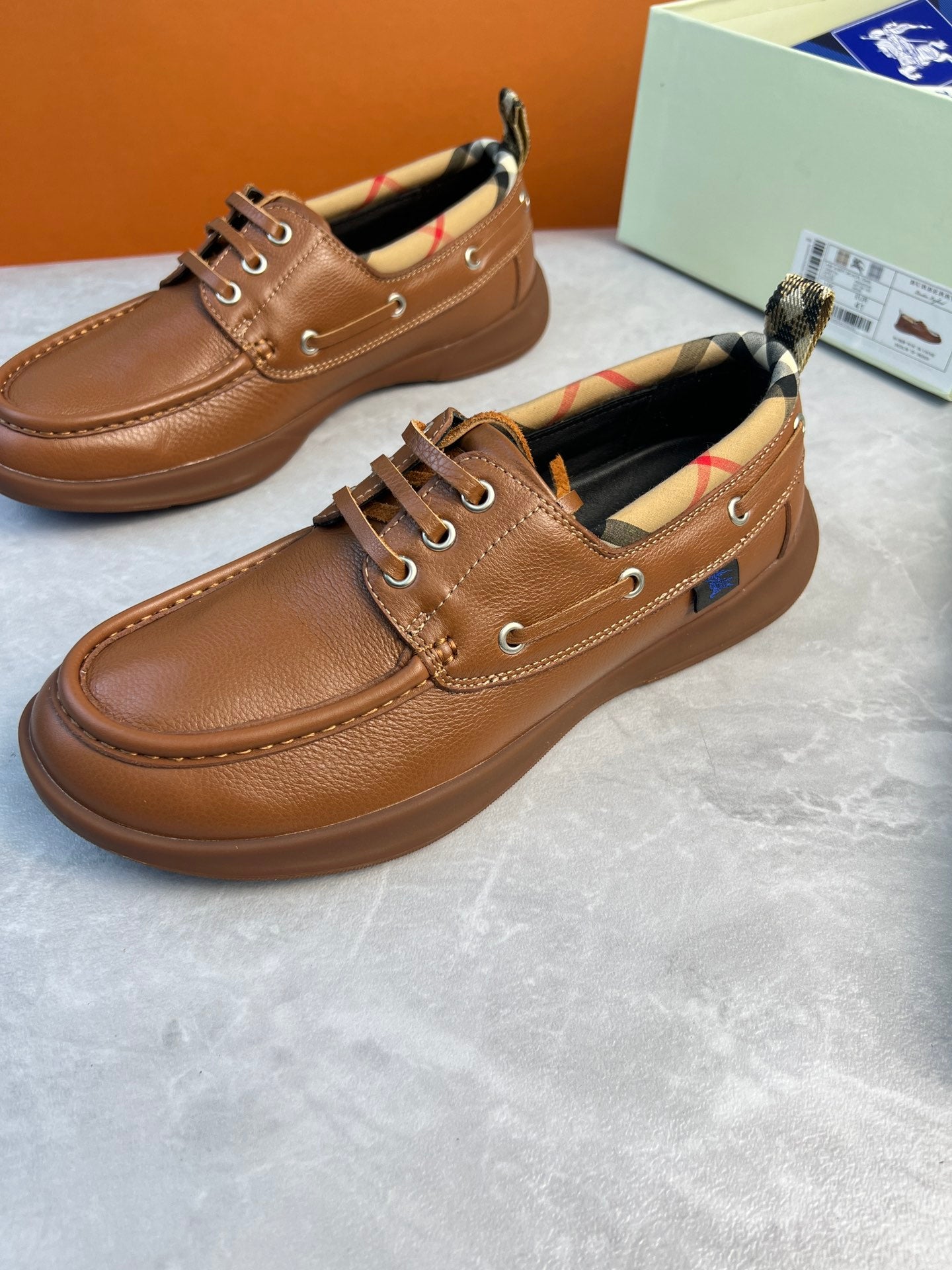 Burberry brown leather lace-up boat shoes with stitched seams and checkered inner collar