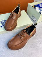 Burberry brown leather lace-up boat shoes with checkered lining and decorative stitching along the upper