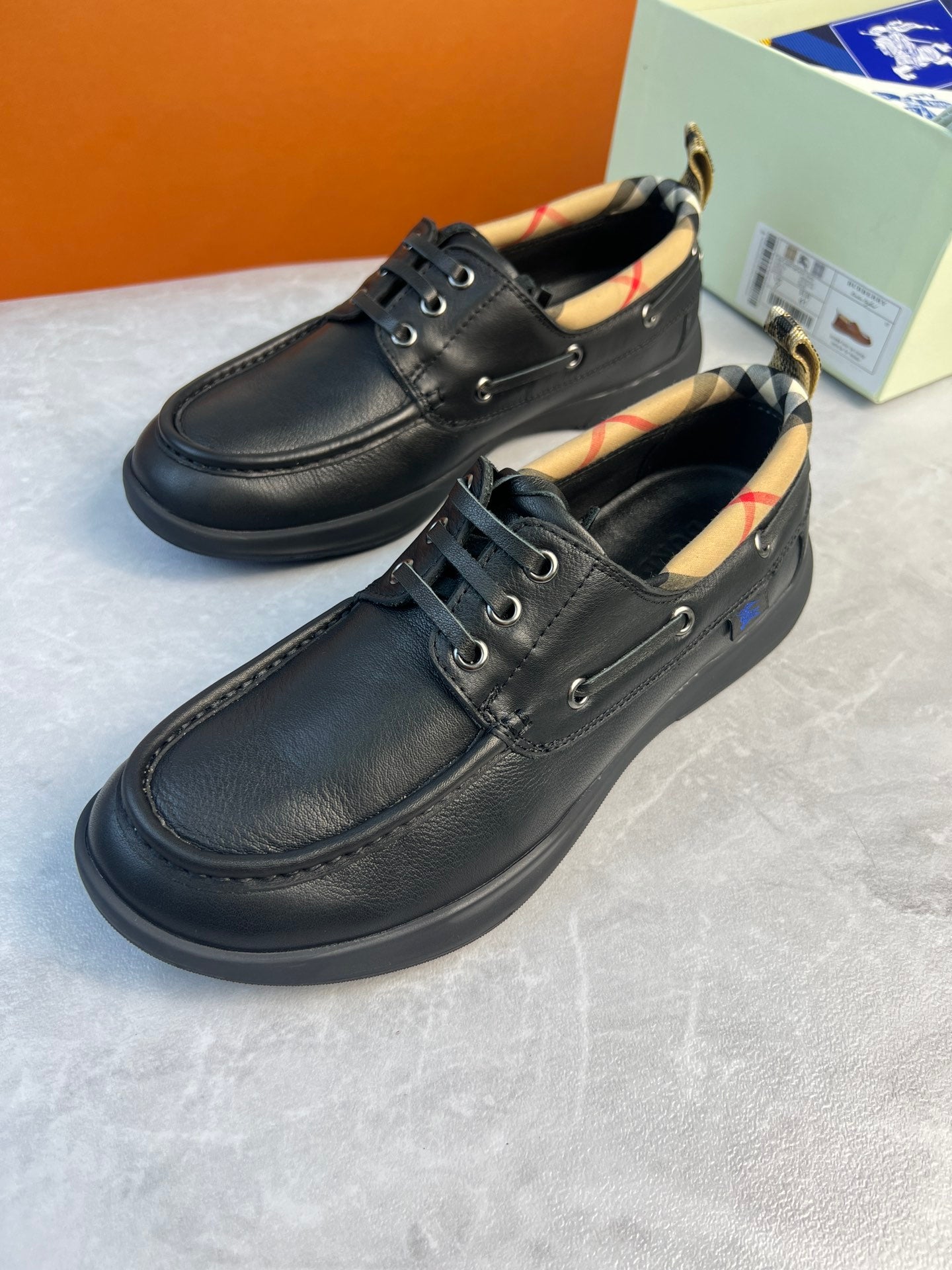 Dark leather lace-up shoes with plaid-lined collar and metal eyelets