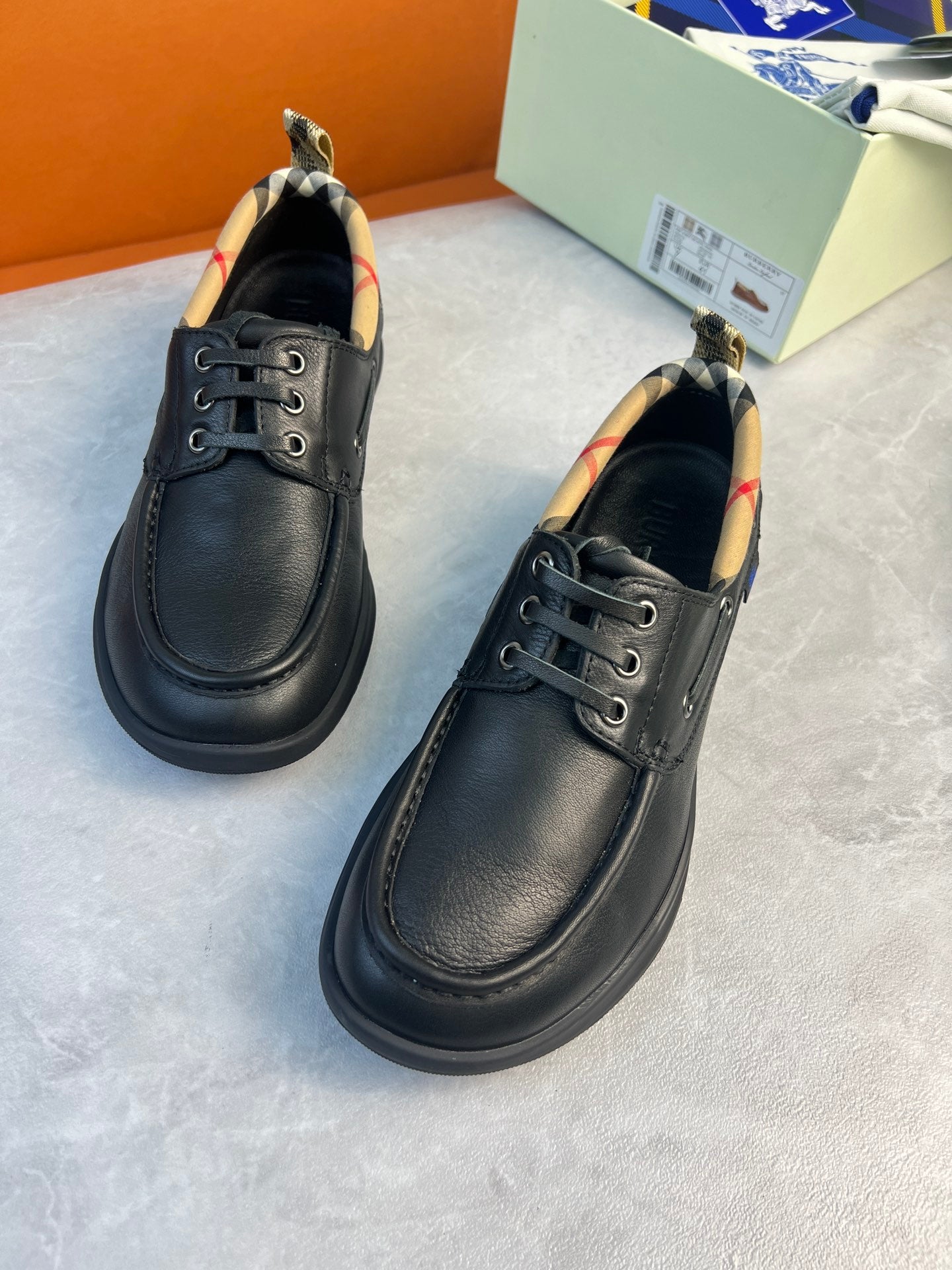 Black leather lace-up shoes with metal eyelets and stitched side panel