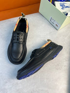 Pair of dark lace-up leather shoes with plaid detail at the collar