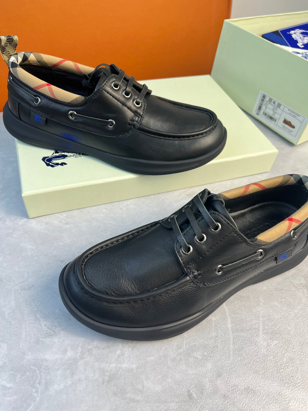 Dark leather lace-up shoes with plaid-lined tongue and metal eyelets