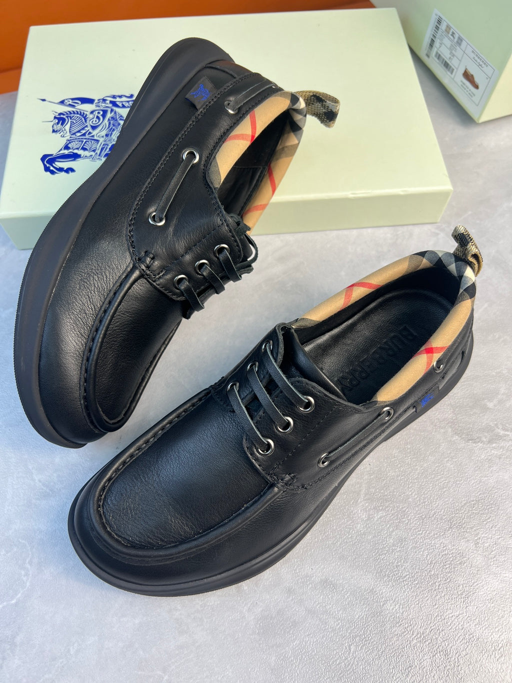 Pair of dark lace-up leather shoes with plaid accents near the collar