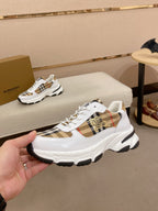 Burberry luxury sneakers on display, white uppers with check plaid and gold emblem
