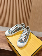 Unisex low-top sneakers pair on yellow box, blue patterned upper with white laces
