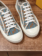 Unisex sneaker pair close-up, blue patterned canvas upper with white rubber sole