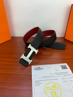Hermes belt with dark textured strap, gold-toned H buckle, and red underside