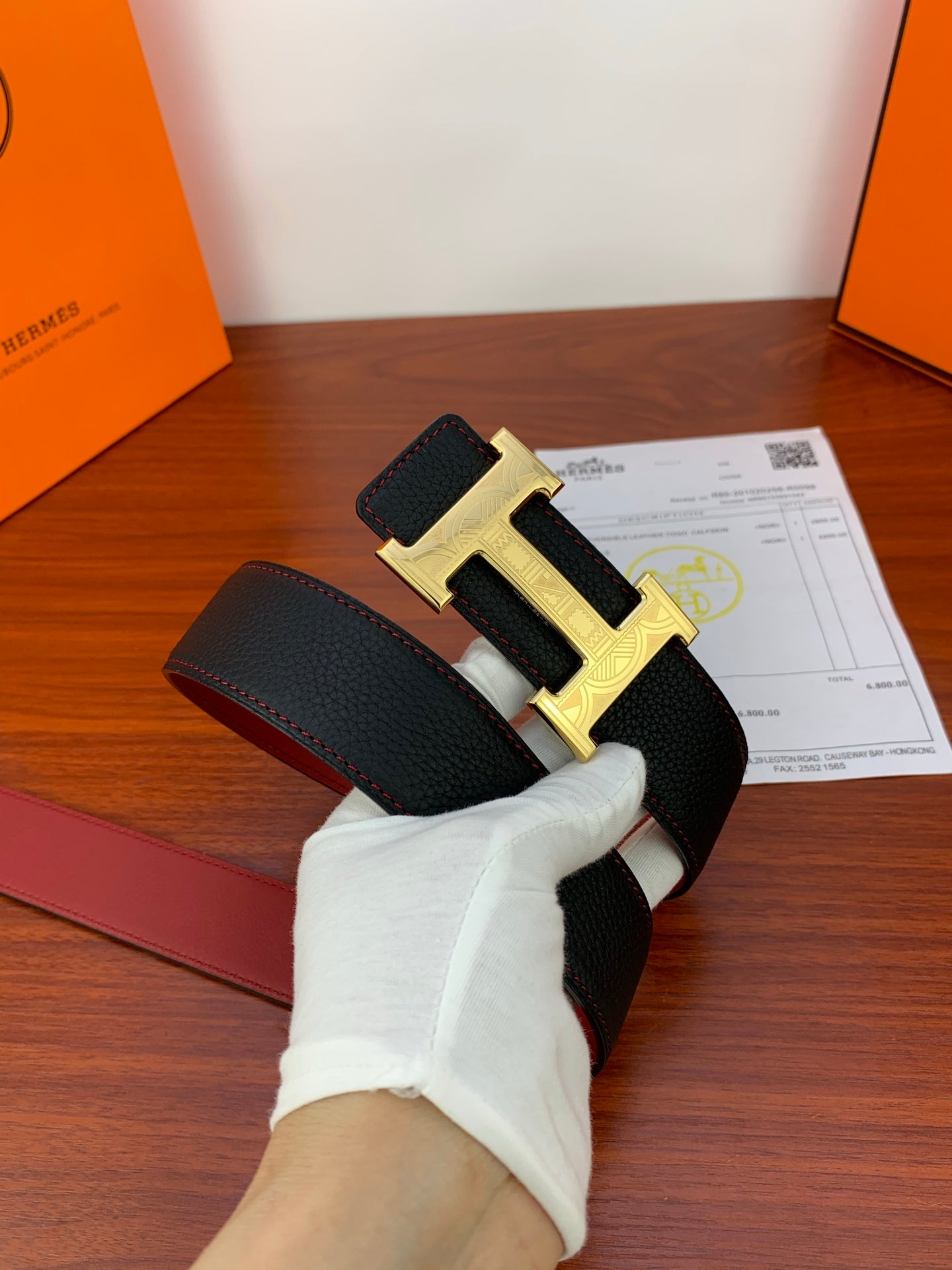 Hermes belt with dark textured strap and gold-toned H buckle