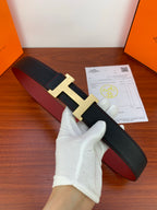 Hermes leather belt, black textured strap with gold H buckle and red underside