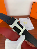 Hermes belt close-up: black textured leather with gold H buckle and red lining