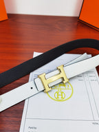 Hermes belt close-up of white textured leather with gold buckle and metal prong