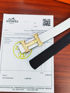 Hermes belt detail with black reversible leather and gold buckle on light strap