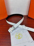 Hermes belt looped on table with light white leather and silver buckle