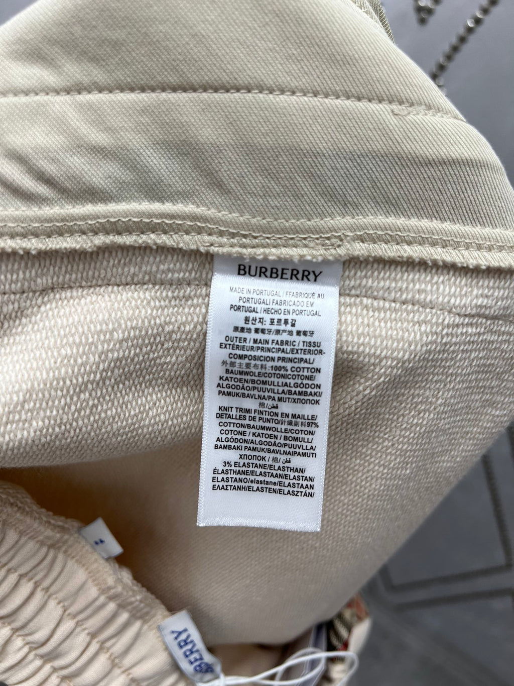 Cream shorts with care label tag and woven fabric texture