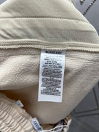Cream shorts with care label tag and woven fabric texture