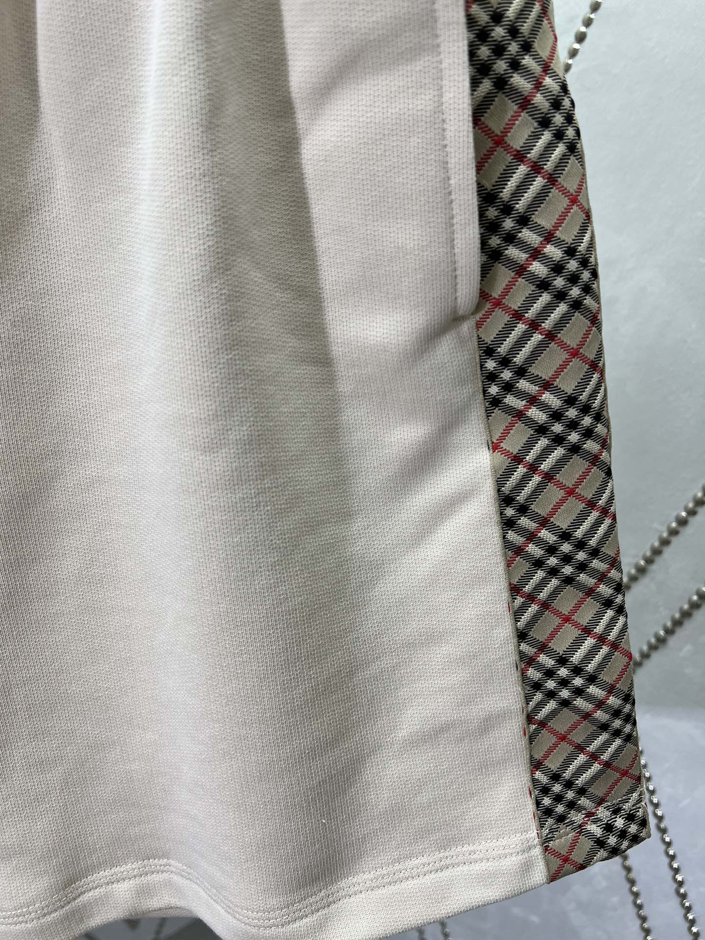 Cream shorts hem with stitched seam and inner plaid lining