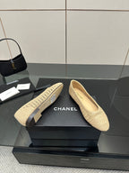 Chanel women’s woven slip-on flats on display, light beige textured upper and flat sole