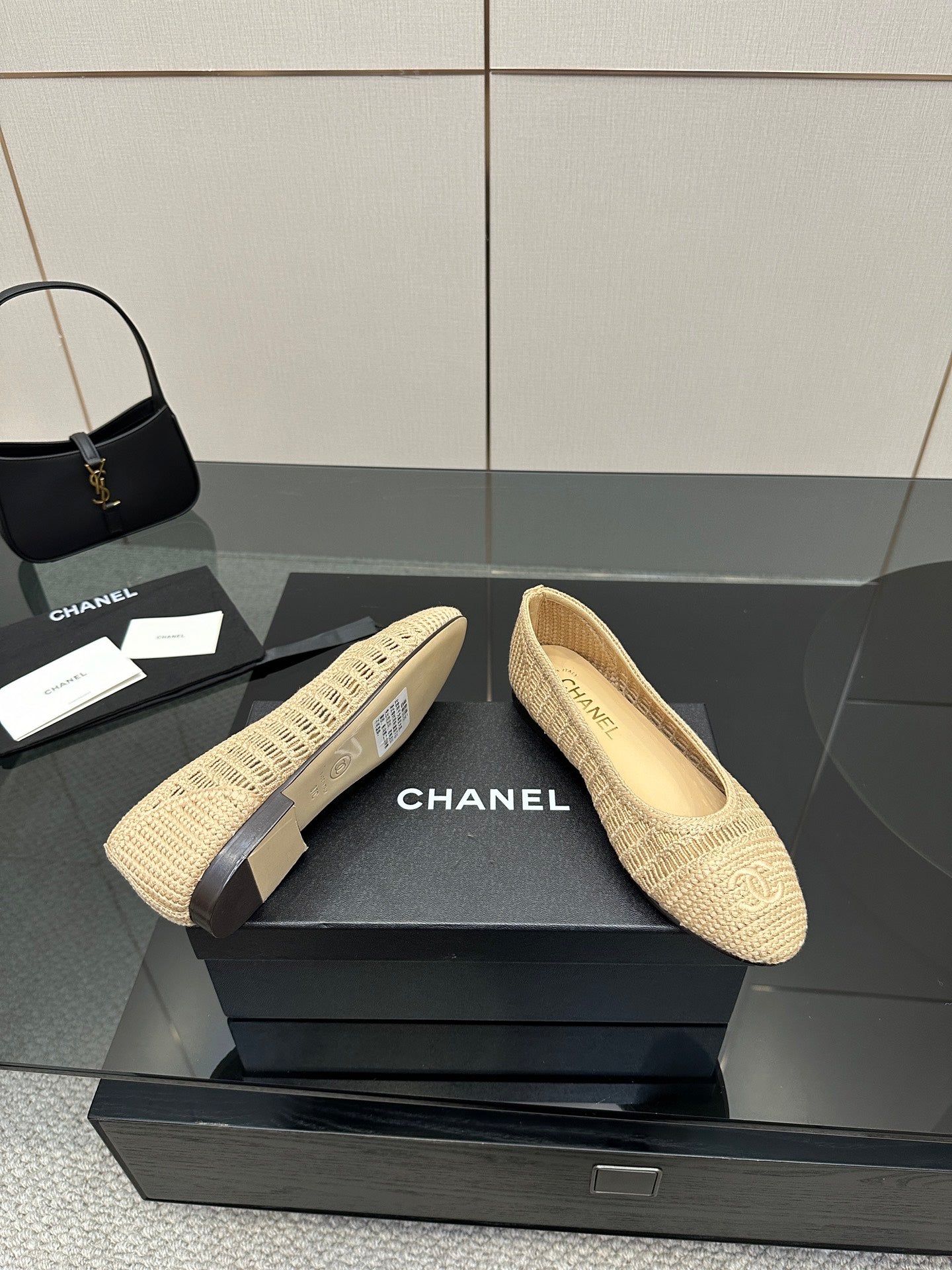 Chanel women’s woven slip-on flats on display, light beige textured upper and flat sole