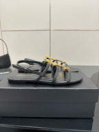 Black flat thong sandals with gold YSL logo on top straps