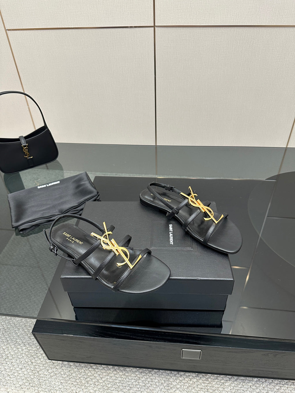 Black leather YSL thong sandals with gold logo on the front strap