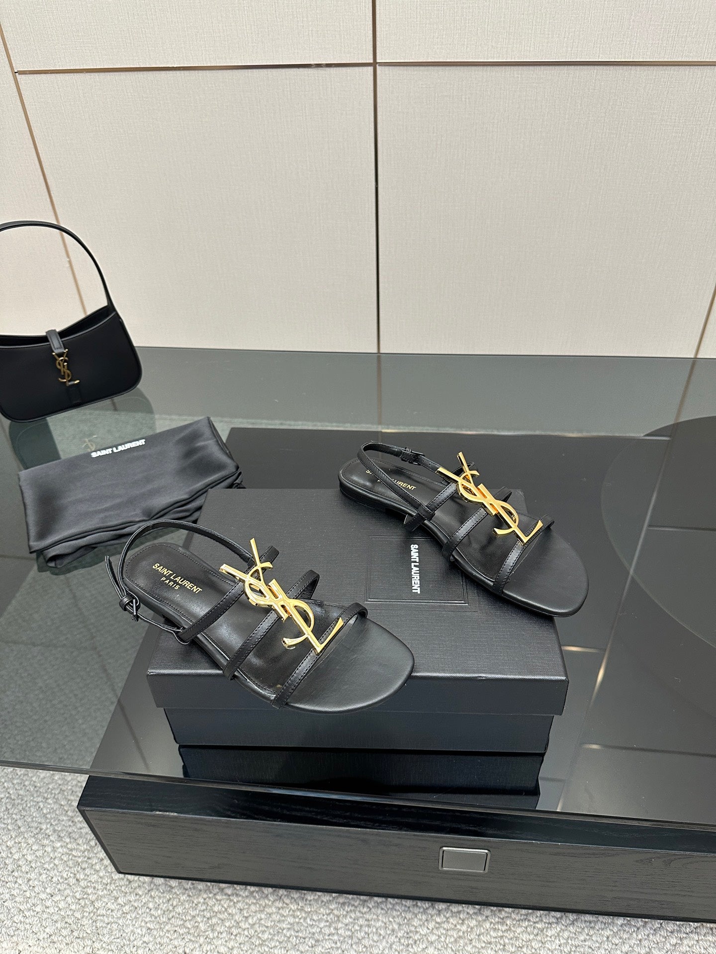 Black leather YSL thong sandals with gold logo on the front strap