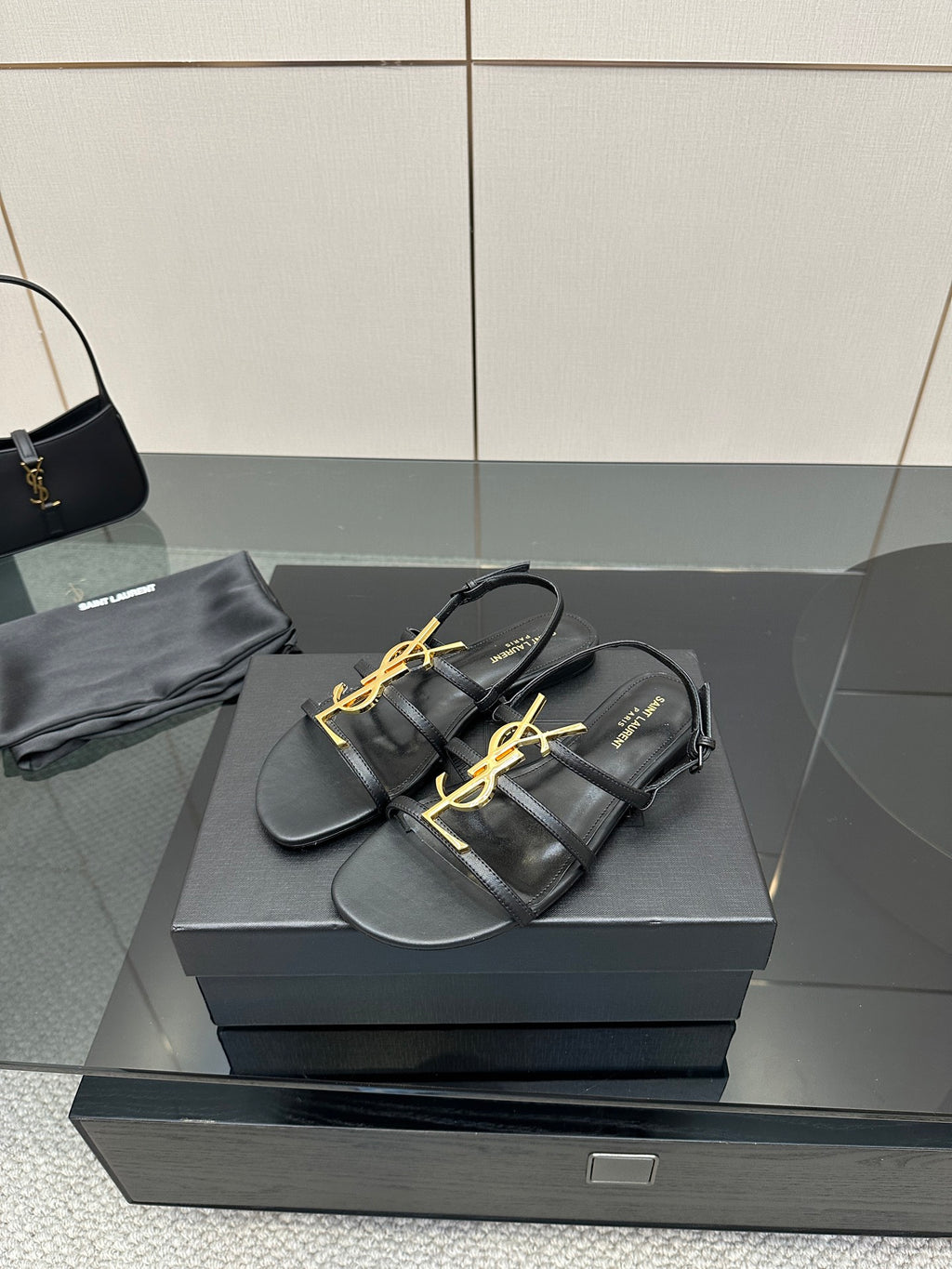 Black thong sandals with gold YSL emblem and flat sole
