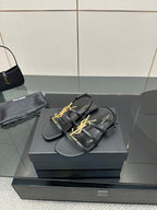 Black thong sandals with gold YSL emblem and flat sole