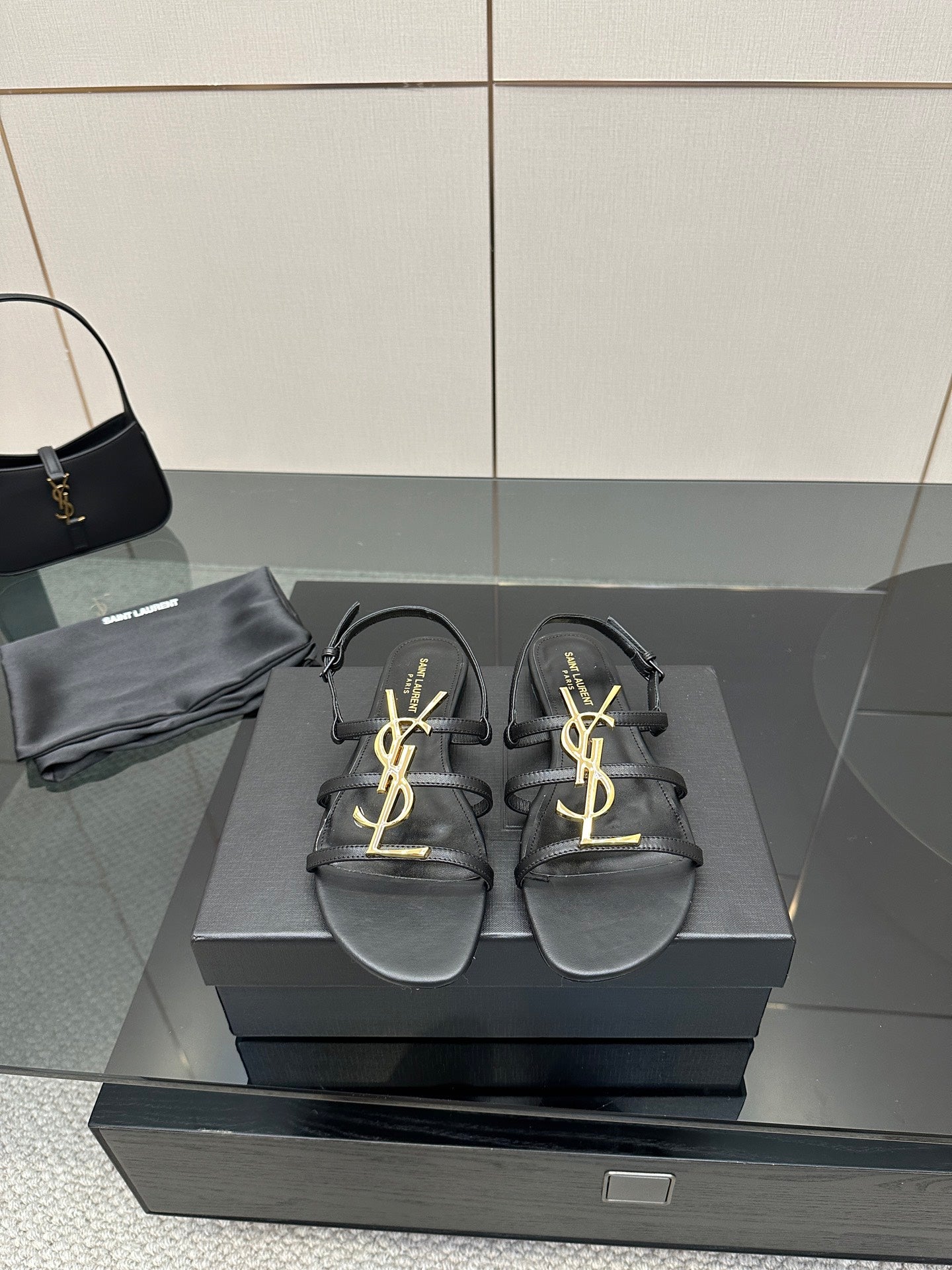 Black leather thong sandals with gold YSL logo on straps