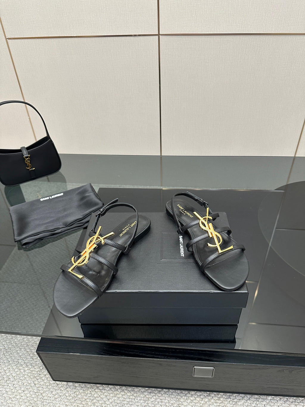 Black YSL thong sandals with gold logo on crossover straps
