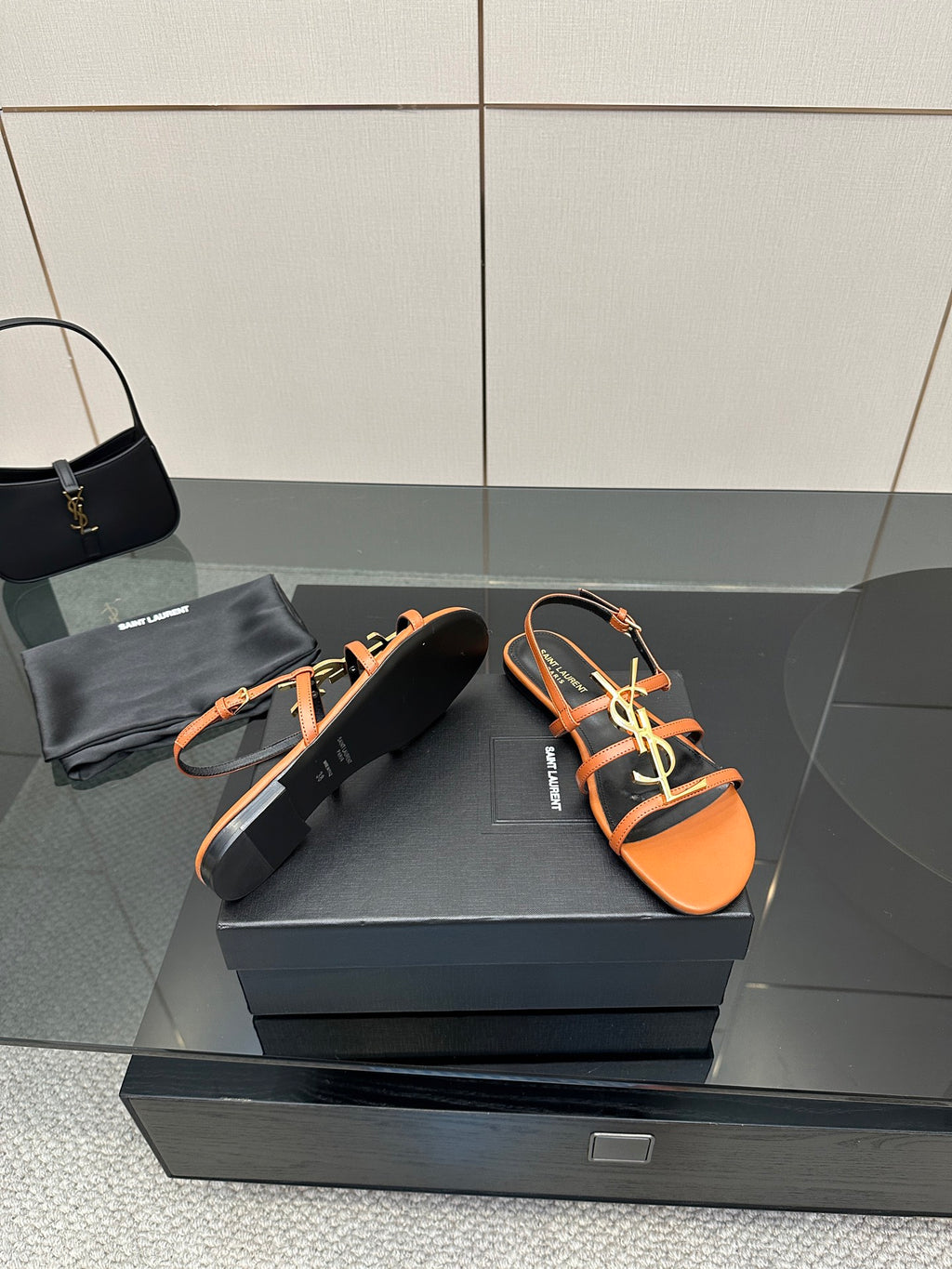 Women's strappy slide sandals in orange and black with gold-tone logo hardware