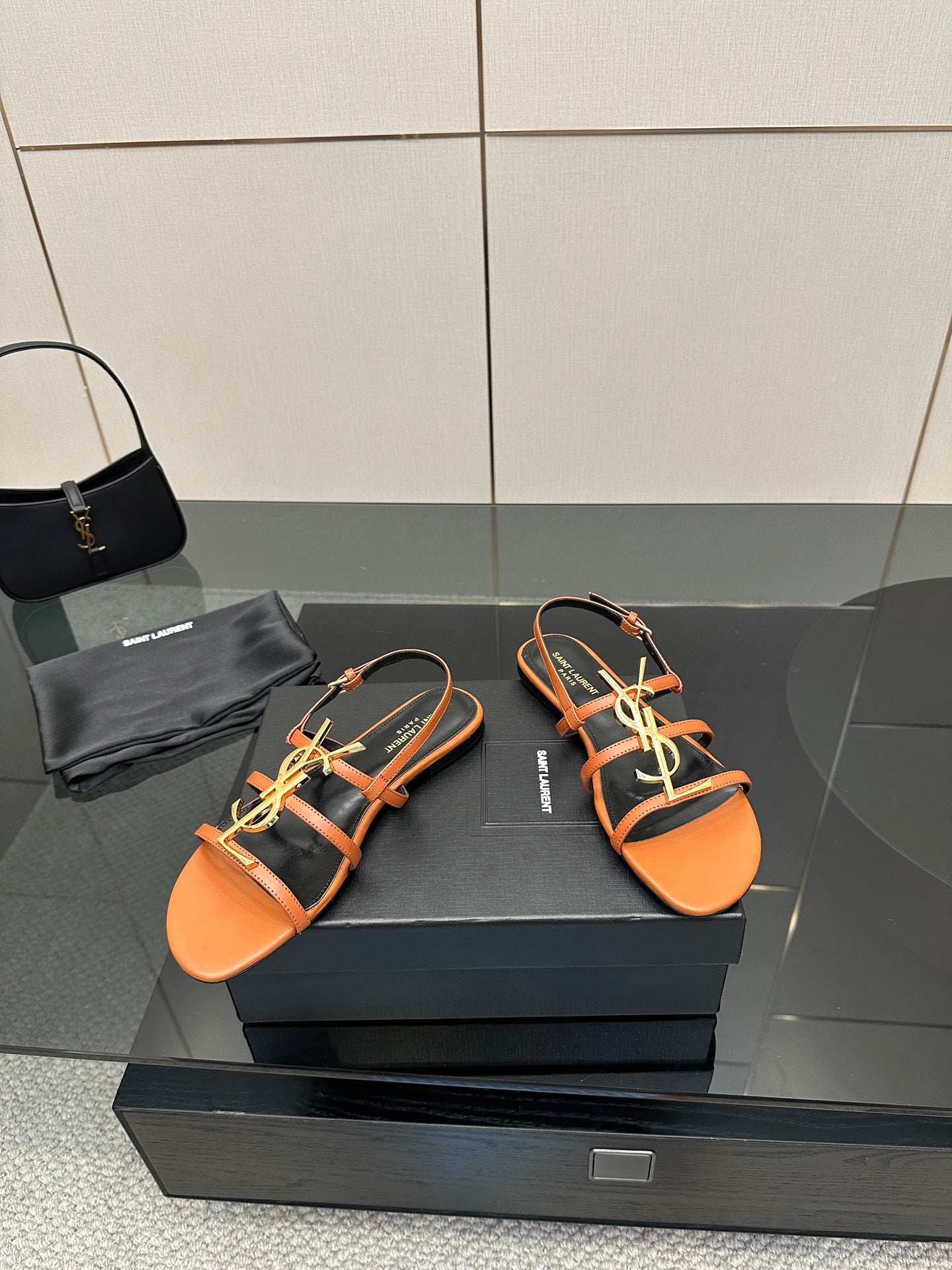 Women's strappy sandals in orange with black straps and gold-tone accent detailing