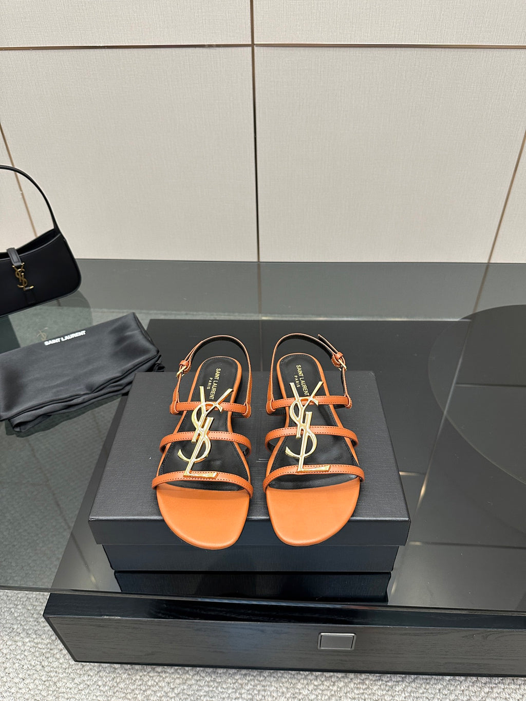 Women's strappy slide sandals in orange with black straps and multicolor logo detail