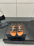Women's strappy slide sandals in orange with black straps and multicolor logo detail