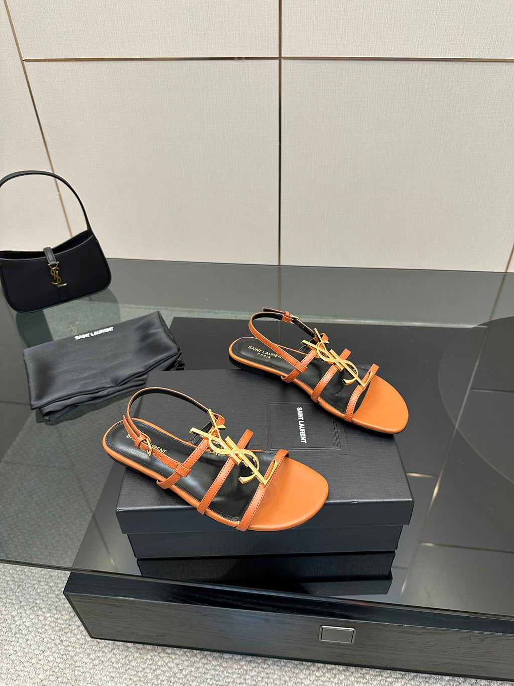 Women's strappy sandals in orange with black straps and gold-tone logo hardware