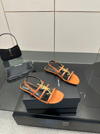 Women's strappy sandals in orange with black straps and gold-tone logo hardware
