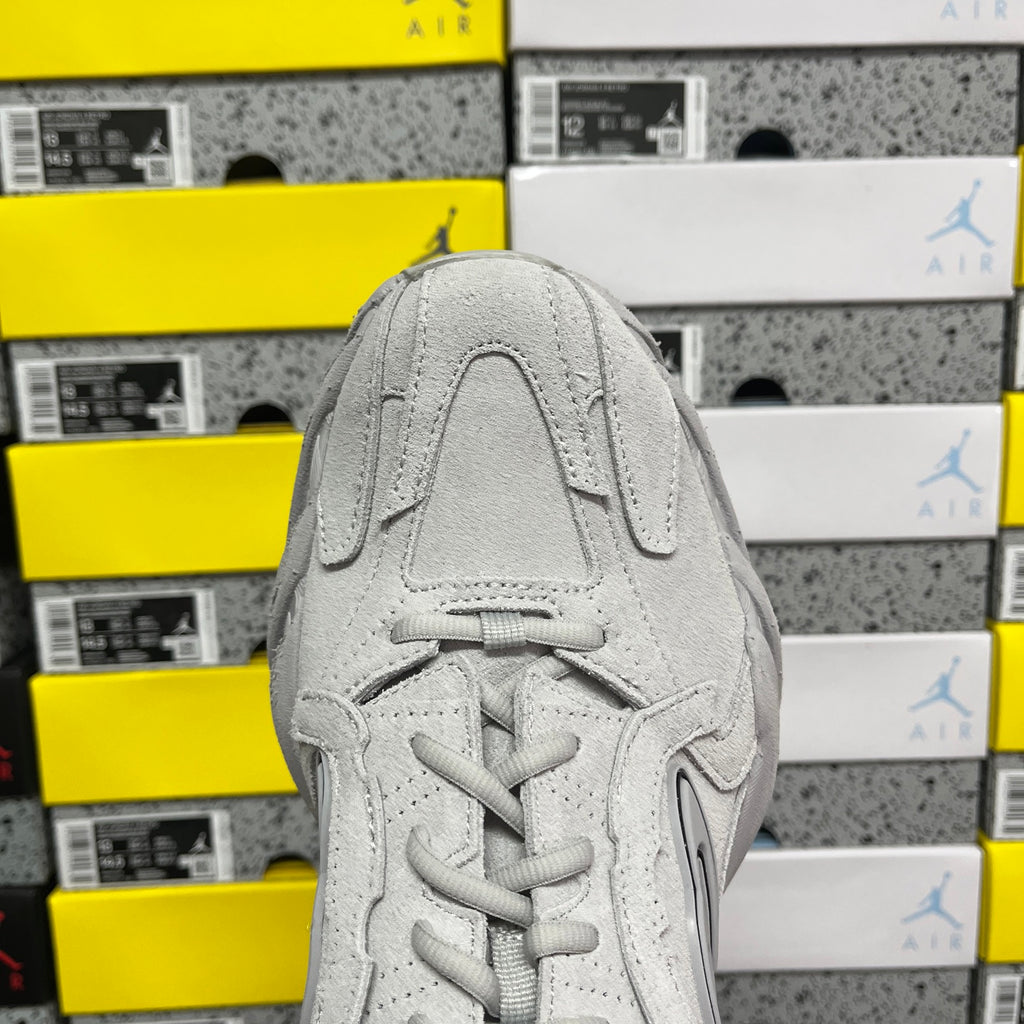 Light gray unisex running sneaker front view with lace-up and textured panel details