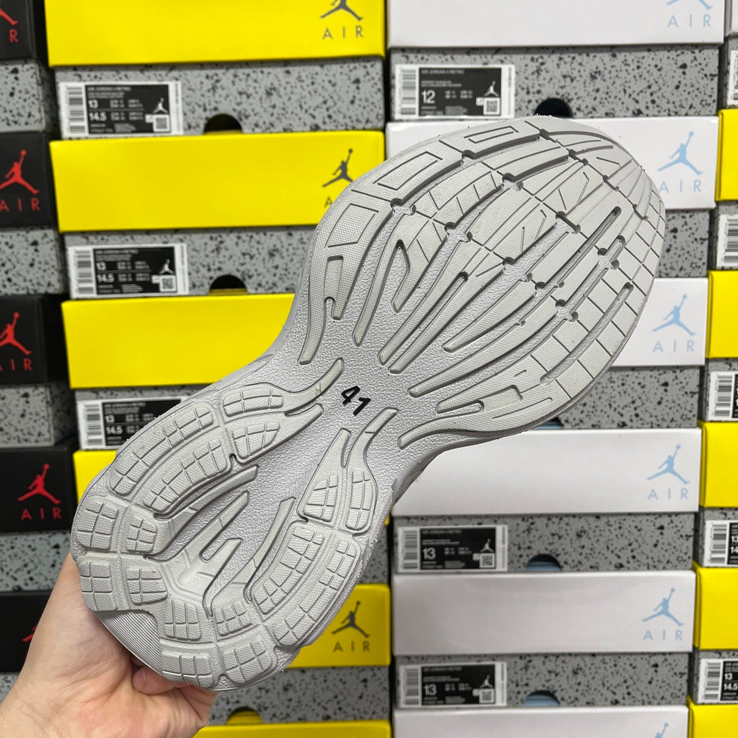 Light gray unisex running sneaker outsole with deep tread pattern and traction grooves