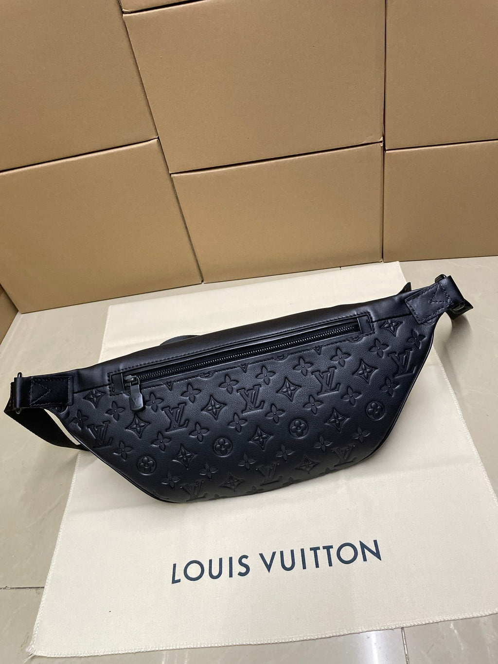Men’s Louis Vuitton monogram sling bag in dark navy, front view with zip pocket