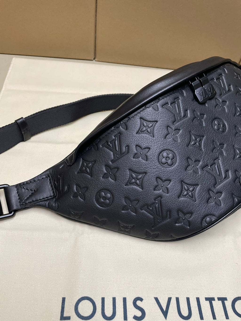 Men’s Louis Vuitton monogram belt bag in dark navy, angled side with strap