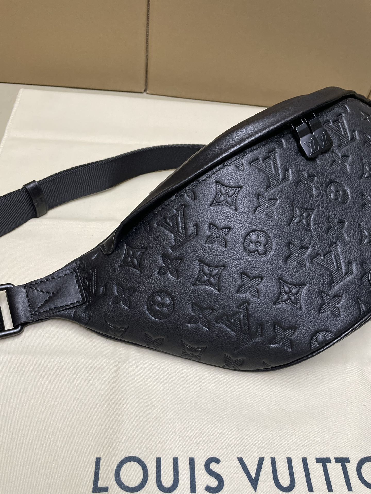 Men’s Louis Vuitton monogram belt bag in dark navy, angled side with strap