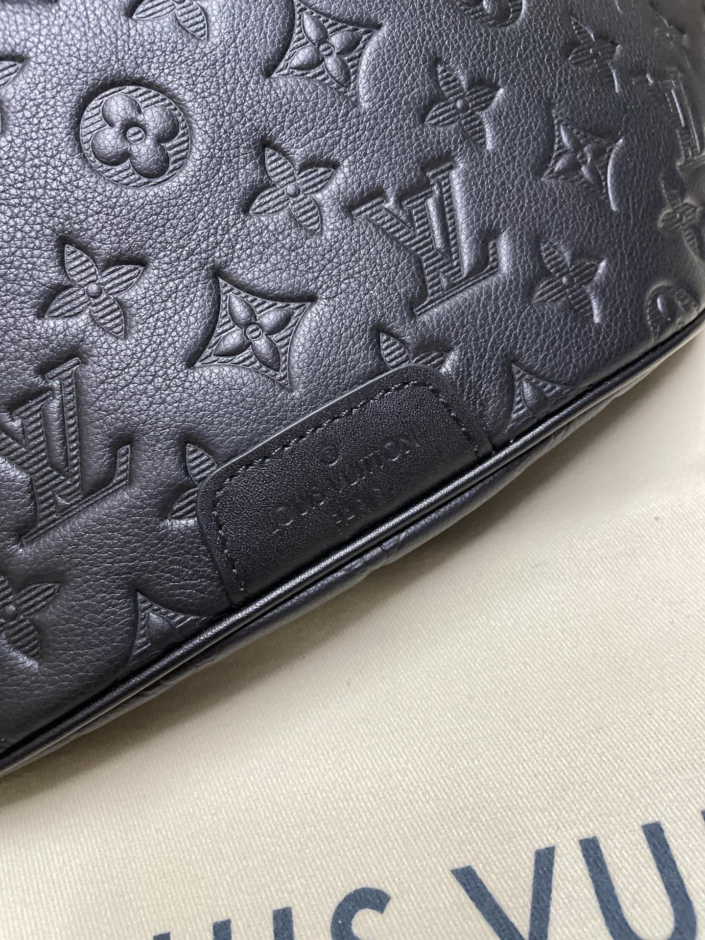 Men’s Louis Vuitton dark navy monogram belt bag close-up of embossed pattern