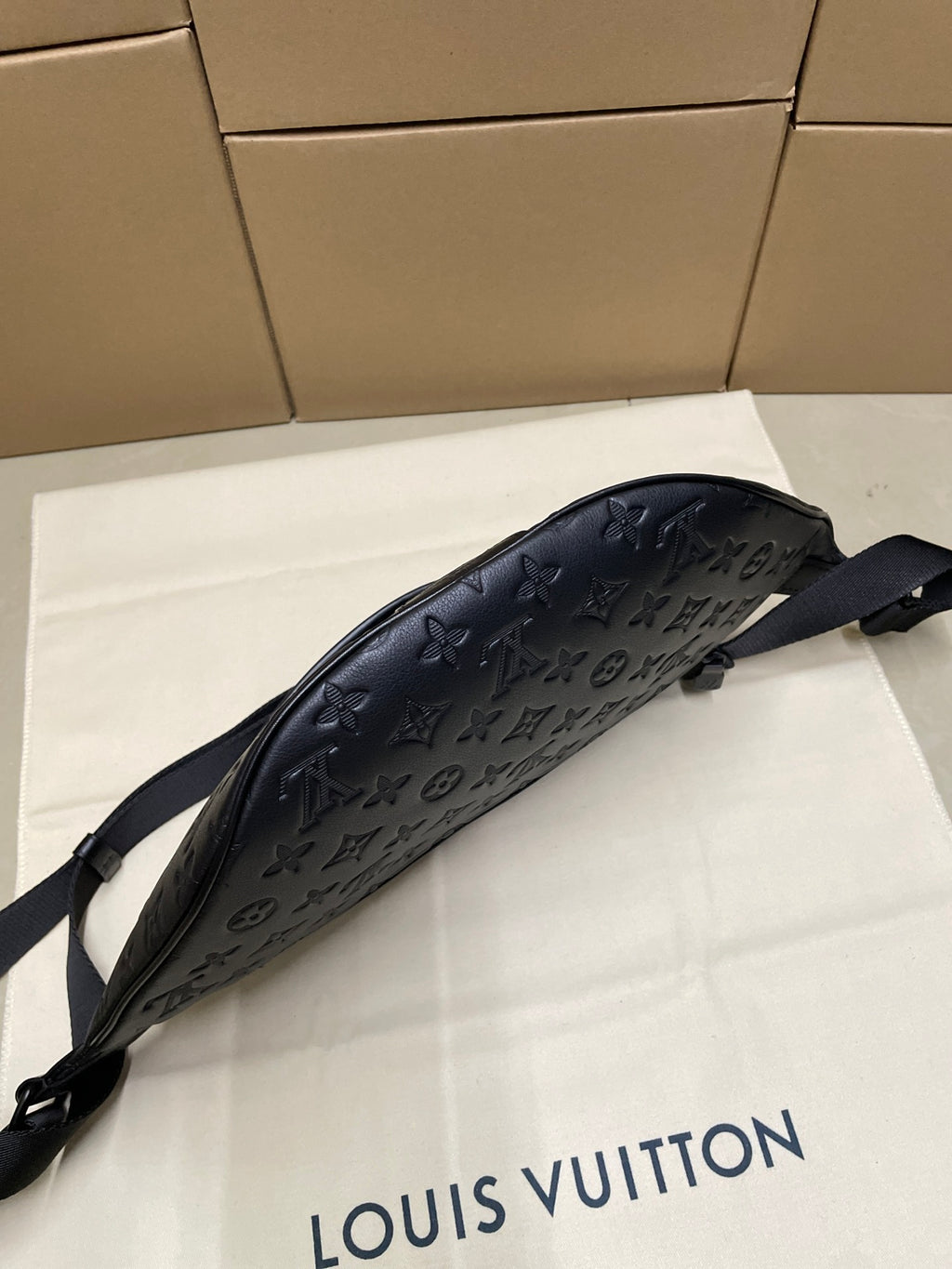Men’s Louis Vuitton monogram sling bag in dark navy with curved silhouette