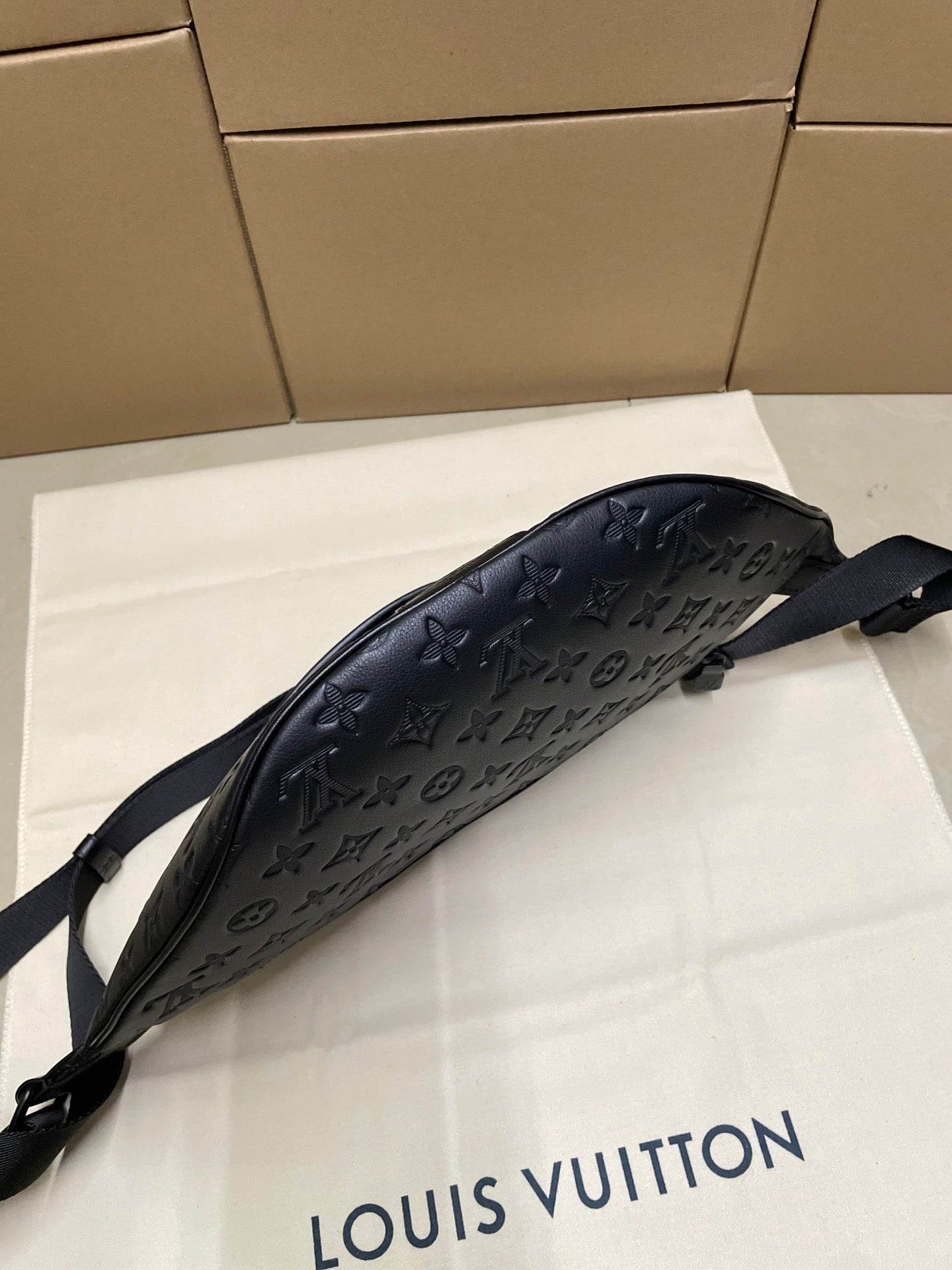 Men’s Louis Vuitton monogram sling bag in dark navy with curved silhouette